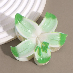 Detailed macro view of elegant white lily hair claw clip with pearlescent finish