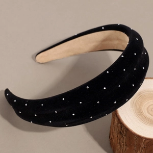 Thick velvet headband in black with shimmering silver rhinestones on a rustic wood base