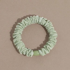 Detailed view of mint green scrunchie with accordion pleats and matching plastic buckle clasp
