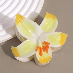 Close-up of yellow and white lily flower hair claw clip with orange stamen detail