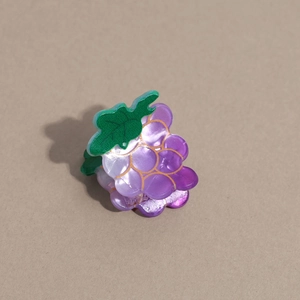 Gros plan détaillé d'une pince à cheveux en forme de raisin en acrylique violet nacré