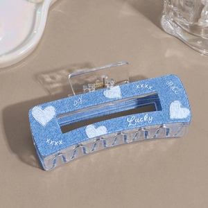 Denim blue heart printed hair claw clip with white lucky letters on beige background
