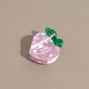 Détail d'une pince à cheveux pêche rose avec feuilles vertes et finition nacrée