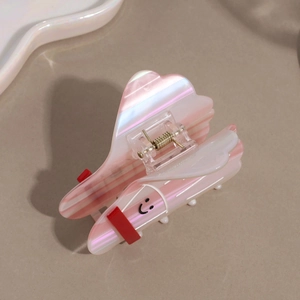 Pink and white striped hair claw clip with smiling face design on beige background
