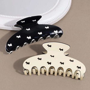 Détail de pinces à cheveux noires et blanches avec motifs de chiens et fini brillant