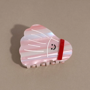 Detailed view of pink badminton shuttlecock hair claw with colorful stripes and smile face