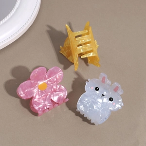 Détail de pinces à cheveux en acétate avec texture marbrée nacrée en formes d'animaux et fleurs