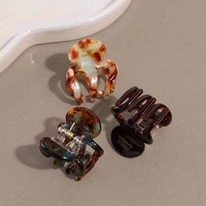 Three-piece set of elegant acetate hair clips with shell patterns and gold letter details