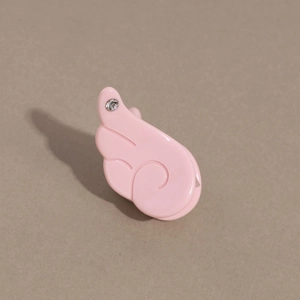 Détail de la mini pince à cheveux aile rose avec finition laquée et un strass étincelant