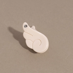 Vue détaillée d'une mini pince à cheveux ailes d'ange blanc crème ornée d'un strass brillant