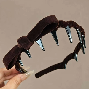 Detail view of dark brown velvet headband with bow and internal non-slip plastic teeth