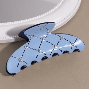 Détail d'une pince à cheveux bleu clair avec motifs de diamants et strass brillants