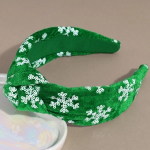 Detail of green velvet knot headband with white sequin snowflakes for Christmas