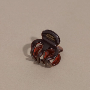 Macro detail of amber acetate hair claw clip showing France Handmade gold lettering
