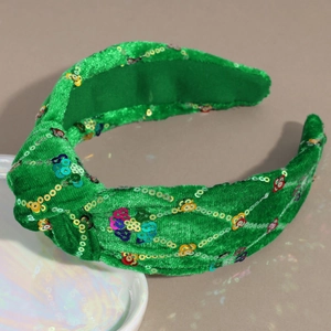 Detail of green velvet wide headband featuring colorful sequins and top knot design