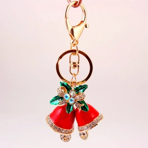 Portachiavi natalizio con campanelle rosse foglie verdi e strass su metallo dorato lucido