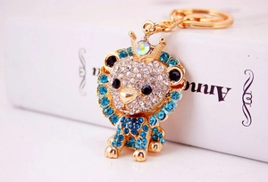 Macro detail of lion keychain with crown, blue mane rhinestones and golden alloy