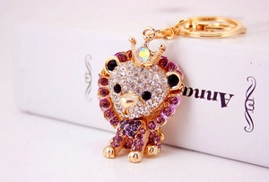 Detailed view of a purple rhinestone lion keychain with a golden crown and sparkling gems