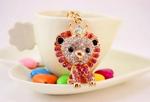 Sparkling lion keychain featuring pink rhinestones and a crown in a cute gift setting