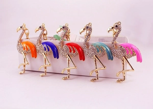 Détail de cinq porte-clés flamant rose ornés de strass en différentes couleurs émaillées