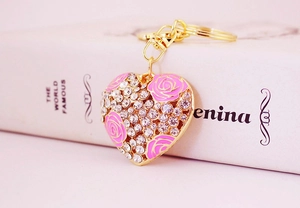 Detailed macro view of heart-shaped keychain with crystal studs and pink roses