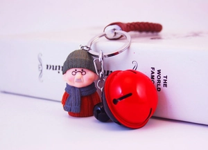 Vue détaillée du porte-clés figurine grand-père avec clochette rouge et cordon cuir