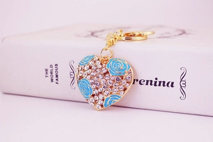 Macro detail of heart keychain with blue enamel roses and sparkling rhinestones