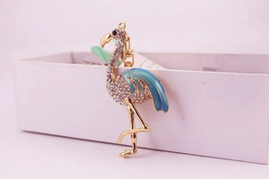 Détail d'un porte-clés flamant rose avec ailes en émail bleu et cristaux incrustés