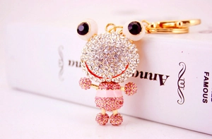 Détail macro du porte-clés grenouille avec strass roses et blancs brillants et dorés