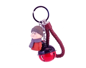 Détail de la poupée grand-père avec cloche en métal et lanière en cuir tressé rouge porte-clés