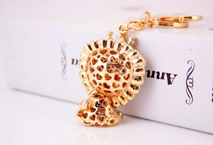 Detailed macro view of the golden lion charm featuring hollow heart patterns on the metal ball