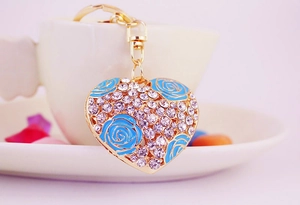 Detail of heart keychain featuring light blue rose enamel and sparkling white rhinestones