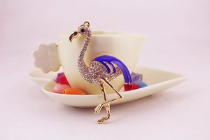Vue macro détaillée du pendentif flamant rose avec émail bleu et cristaux brillants