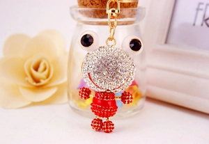 Détail du porte-clés grenouille étincelant avec robe en cristal rouge et base dorée