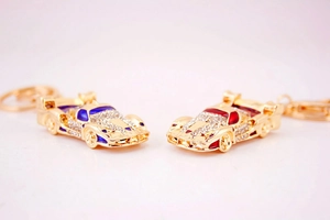 Close-up of red and blue rhinestone racing car keychains with golden alloy finish