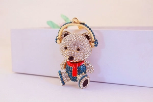Detailed close-up of a sparkling teddy bear keychain with blue and white rhinestones