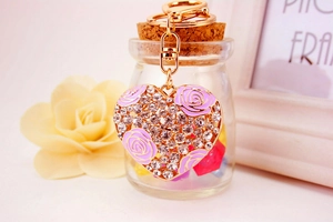 Detail of heart keychain with purple enamel roses and crystals on a golden alloy ring