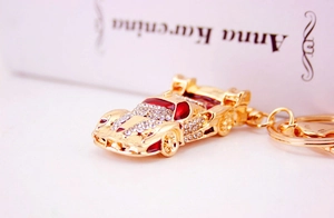 Macro shot of luxury sports car keychain with gold plating and white sparkling crystals