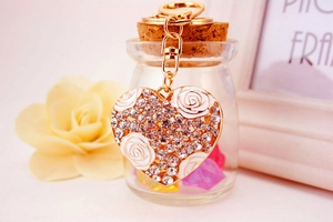 Detailed view of gold alloy heart keychain with white enamel roses and crystals
