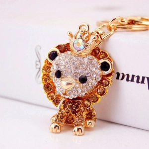 Sparkling rhinestone lion keychain with crown in golden finish on white background