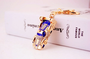 Detail of luxury rhinestone car keychain with blue enamel coating and gold metal ring