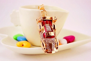 Detail of a golden sport car keychain with red enamel and sparkling crystal rhinestones