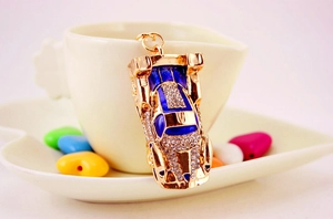 Macro shot of gold car keychain with blue enamel details and shiny rhinestones