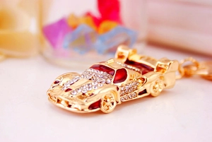 Macro shot of creative sports car keychain with red enamel and sparkling rhinestones
