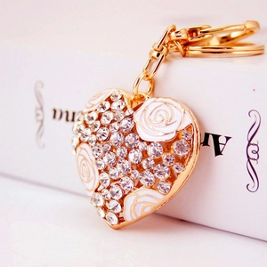 Exquisite golden heart keychain with white enamel roses and shimmering rhinestones