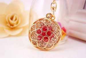 Detailed macro of golden floral keychain with pink gradient rhinestones and hollow metalwork