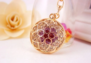 Macro shot of gold floral keychain featuring sparkling purple and white rhinestones detail