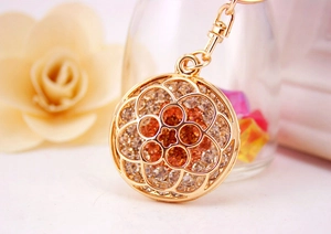Macro detail of golden hollow flower keychain with sparkling crystals for bag accessory