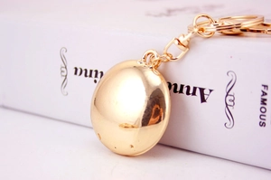 Detailed view of a golden polished round metal keychain charm with lobster clasp accessory