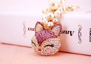 Detailed close-up of pink fox keychain with faux pearls and sparkling rhinestones